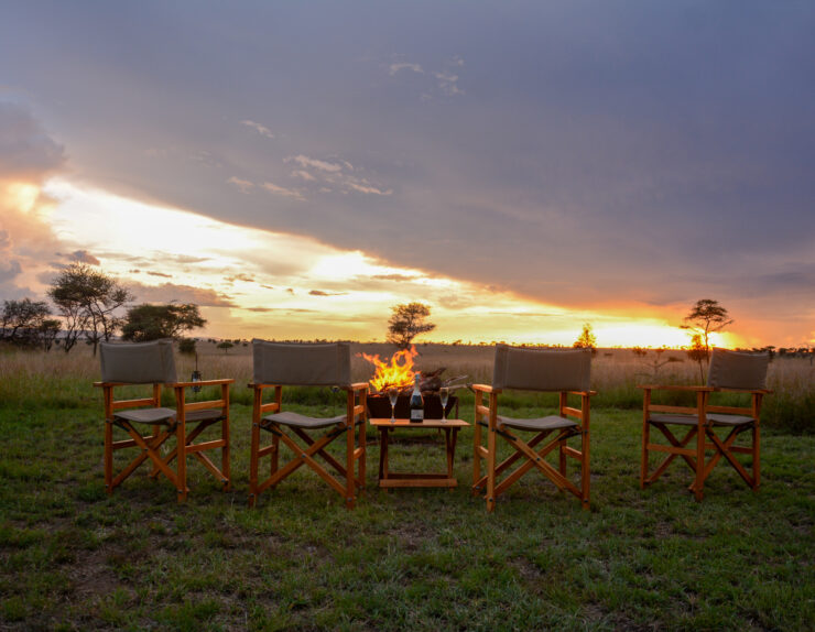 Serengeti sunset safari with golden sky over vast savannah at Manya Luxury Camps, Tanzania.